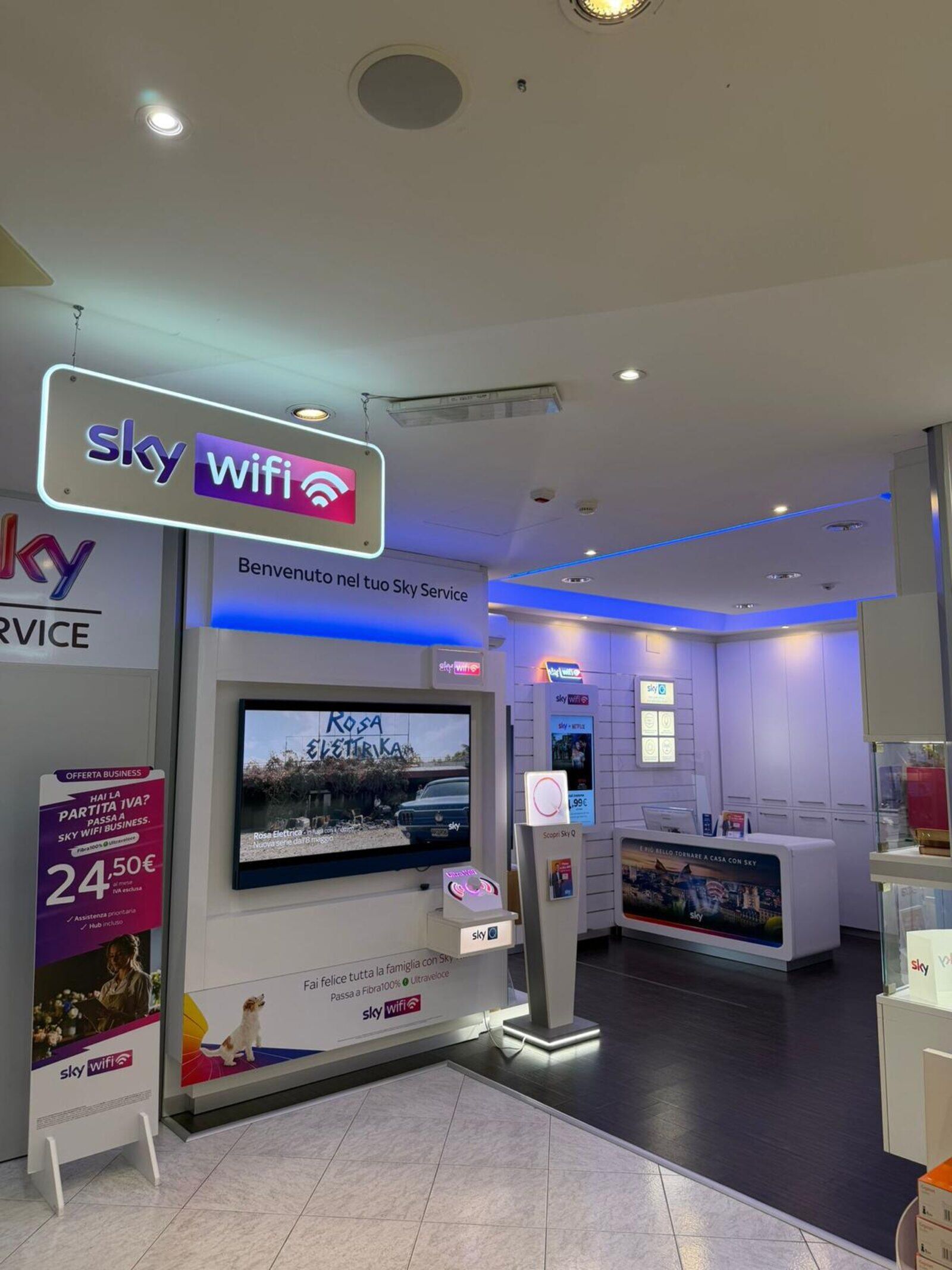 Sala principale del punto vendita 3sat di Martina Franca: bancone, parete TV Sky, illuminazione brand.